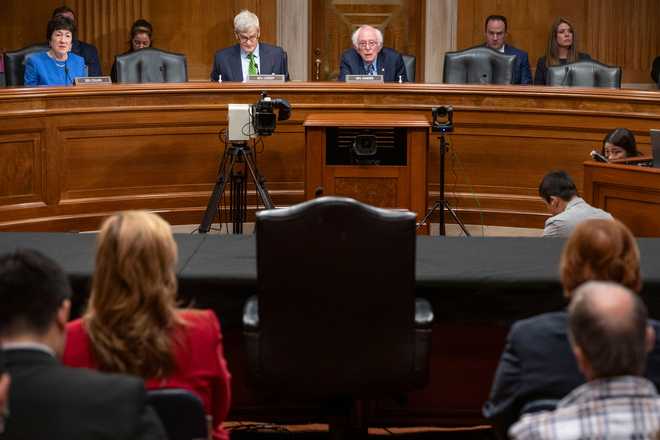 sen. Bernie Sanders, i-vt., Top Center, along with other senators and staffers, look at the empty chair reserved for health care administrator Ceo Ralph de la Torre, which is left empty after de la Torre failed to appear and testify in a Senate Health, Education, Labor and Pensions hearing to examine the health administrator's bankruptcy on Thursday, September. October 12, 2024 at the Capitol in Washington. (ap photo/kevin wolf)