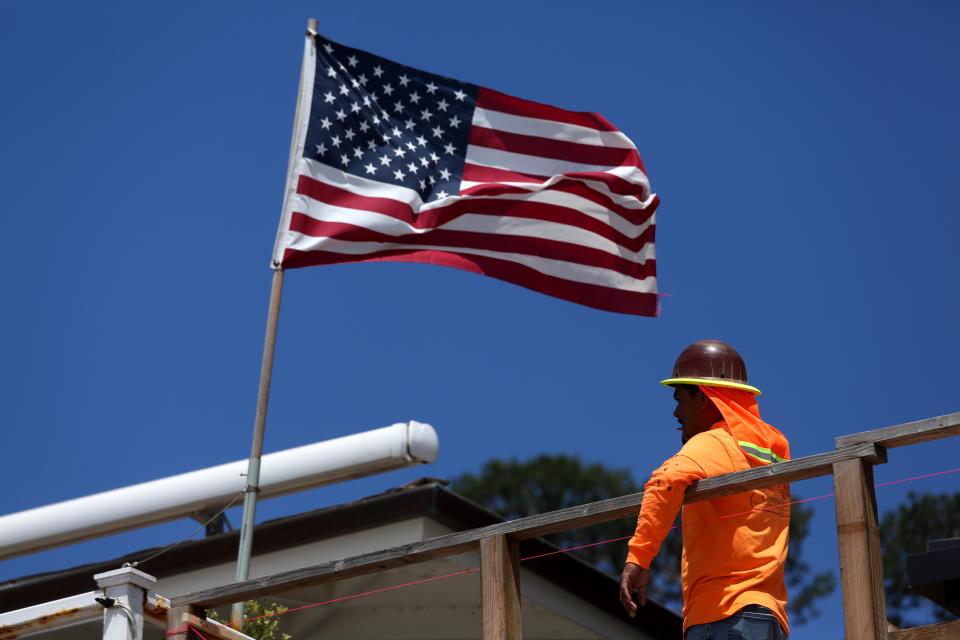 MALIBU, CA - JULY 3, 2024 - A construction worker takes a break to catch a breeze while taking a break from work under an American flag in Malibu on July 3, 2024. (Genaro Molina/Los Angeles Times via Getty Images)